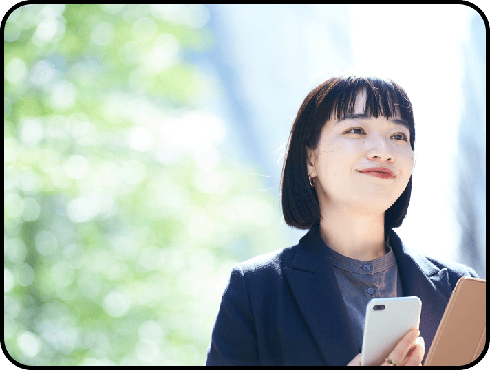 スマートフォンを持ち、未来を見据える女性社員